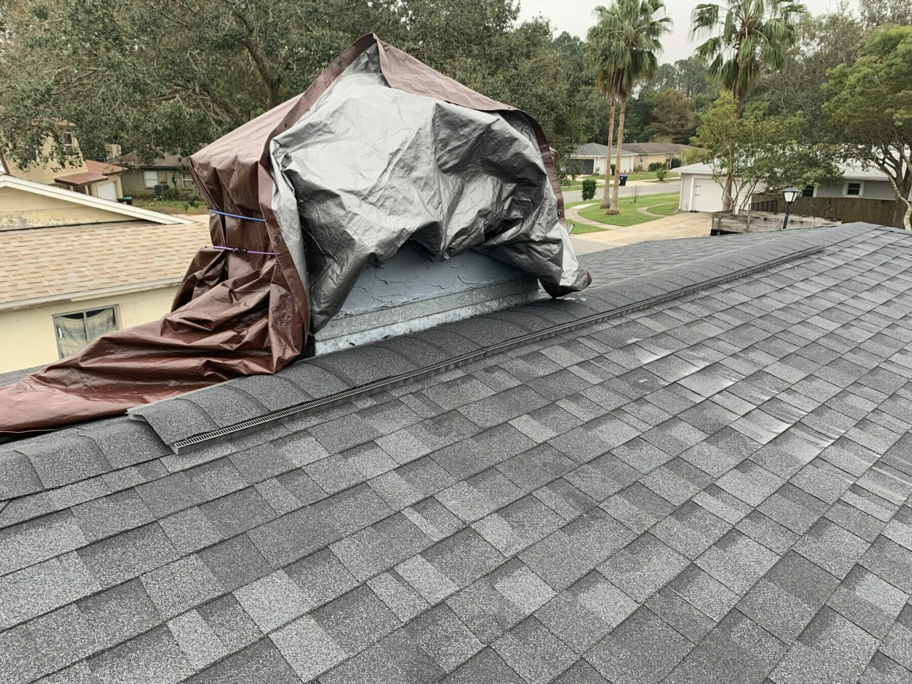 Tarp on chimney and new shingles on roof